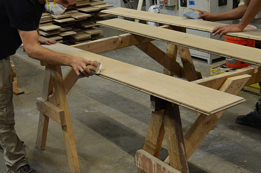 worker applying hardwood wax at finish mill